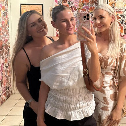 Three friends in a mirror selfie with a Bloomy case